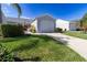 House exterior featuring a gray garage and well-manicured lawn at 1256 Spoonbill Landings Cir, Bradenton, FL 34209