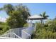White gazebo with walkway bridge over lush tropical landscaping at 1256 Spoonbill Landings Cir, Bradenton, FL 34209
