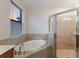Bathroom with soaking tub, walk-in shower, and window at 13627 American Prairie Pl, Lakewood Ranch, FL 34211