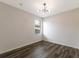Bright bedroom with dark wood floors and modern light fixture at 13627 American Prairie Pl, Lakewood Ranch, FL 34211