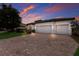 Two-story house with a brick driveway and three-car garage, at sunset at 13627 American Prairie Pl, Lakewood Ranch, FL 34211
