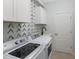 Laundry room with washer, dryer, cabinets, and stylish wallpaper at 13627 American Prairie Pl, Lakewood Ranch, FL 34211