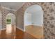 Entryway with arched doorways, floral wallpaper, and hardwood floors at 1616 North Dr, Sarasota, FL 34239