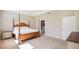 Spacious bedroom with a wooden post bed and ensuite bathroom at 16926 Harvest Moon Way, Bradenton, FL 34211
