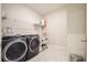 Bright laundry room with washer, dryer and shelving at 16926 Harvest Moon Way, Bradenton, FL 34211