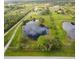 Aerial view highlighting a pond and surrounding landscape at 31730 Clay Gully Rd, Myakka City, FL 34251