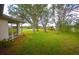 Large grassy backyard with mature trees and screened porch at 31730 Clay Gully Rd, Myakka City, FL 34251