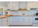 Modern kitchen with white cabinets, butcher block countertops, and subway tile backsplash at 321 Hills Rd, Nokomis, FL 34275