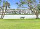 Peaceful lakeside view with a bench, lush greenery and building in the background at 3546 Lake Bayshore Dr # K-124, Bradenton, FL 34205