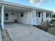 Front view of a white house with carport and blue accents at 573 Spanish N Dr, Longboat Key, FL 34228