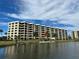 Exterior view of a condo building near a lake at 5760 Midnight Pass Rd # 307D, Sarasota, FL 34242