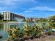Attractive building exterior with lakefront views and landscaping at 5760 Midnight Pass Rd # 307D, Sarasota, FL 34242