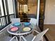 View of the cozy balcony with glass table and four chairs, overlooking the bedroom at 5760 Midnight Pass Rd # 307D, Sarasota, FL 34242