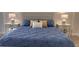 Comfortable bedroom with a blue comforter and decorative pillows atop a tile floor at 5760 Midnight Pass Rd # 307D, Sarasota, FL 34242