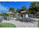 Outdoor kitchen and dining area with thatched umbrellas and picnic tables at 5760 Midnight Pass Rd # 307D, Sarasota, FL 34242