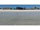 Clear water view of beach with condo buildings in distance at 5760 Midnight Pass Rd # 307D, Sarasota, FL 34242