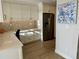 Bright kitchen boasts stainless steel refrigerator, white cabinets, modern backsplash, and wood-look tile flooring at 5760 Midnight Pass Rd # 307D, Sarasota, FL 34242