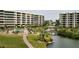 Community overview featuring a canal, pool, landscaping, and condo buildings at 5760 Midnight Pass Rd # 307D, Sarasota, FL 34242