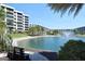 Tranquil lake view with a bench and resort buildings in the background at 5760 Midnight Pass Rd # 307D, Sarasota, FL 34242