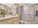 Clean bathroom featuring white tile, safety bars, and a neutral-patterned shower curtain at 5770 Midnight Pass Rd # 705C, Sarasota, FL 34242
