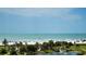 Beautiful beach view featuring the ocean, palm trees, a pond, and an American flag on a sunny day at 5770 Midnight Pass Rd # 705C, Sarasota, FL 34242