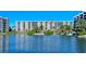 Exterior water view of a beachfront condominium complex surrounded by lush landscaping and blue skies at 5770 Midnight Pass Rd # 705C, Sarasota, FL 34242