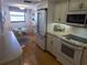 This is an eat-in kitchen featuring updated appliances, cabinets, and hardwood floors at 5770 Midnight Pass Rd # 705C, Sarasota, FL 34242