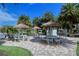 Community picnic area with tiki-style umbrellas, built-in grill and surrounded by landscaping near a pond at 5770 Midnight Pass Rd # 705C, Sarasota, FL 34242