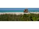 Lifeguard stand on a sandy beach with ocean and people in the background at 1064 N Tamiami Trl # 1311, Sarasota, FL 34236