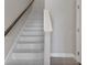 Interior staircase with light grey tile and dark wood handrail at 1904 Monte Carlo Dr, Sarasota, FL 34231