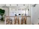 Kitchen with white cabinets, breakfast bar with three chairs, and appliances at 475 Benjamin Franklin Dr # 209, Sarasota, FL 34236