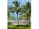 Community pool and beach access with lounge chairs and palm trees at 475 Benjamin Franklin Dr # 209, Sarasota, FL 34236