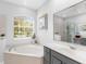 Relaxing bathroom with a corner soaking tub and gray vanity at 6828 Coyote Ridge Ct, University Park, FL 34201