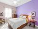 Bright bedroom with double bed and lavender walls at 6828 Coyote Ridge Ct, University Park, FL 34201