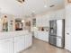 Kitchen with white cabinets, stainless steel refrigerator, and island at 6828 Coyote Ridge Ct, University Park, FL 34201