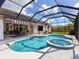 Expansive screened pool and spa with an outdoor dining area at 6828 Coyote Ridge Ct, University Park, FL 34201
