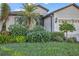 Landscaped front yard with lush greenery and flowering plants at 8231 Stirling Falls Cir, Sarasota, FL 34243