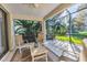 Bright screened patio overlooks lush greenery, ideal for relaxation at 8231 Stirling Falls Cir, Sarasota, FL 34243
