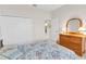 Bedroom with floral bedding and wooden dresser and mirrored closet at 8231 Stirling Falls Cir, Sarasota, FL 34243