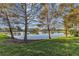 Scenic view of a lake with lush green grass and mature trees at 8231 Stirling Falls Cir, Sarasota, FL 34243