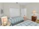 Bedroom with twin beds, each with plaid bedding, and shared bath at 8231 Stirling Falls Cir, Sarasota, FL 34243