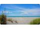 Wide beach view with soft sand, clear skies, and aqua ocean water visible in the background at 108 Shell Rd, Venice, FL 34293