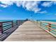 Scenic pier view with wooden planks, blue skies, and handrails overlooking the ocean at 108 Shell Rd, Venice, FL 34293