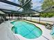 Inviting kidney-shaped pool with a screened enclosure and comfortable lounge chairs at 108 Shell Rd, Venice, FL 34293