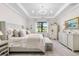 Elegant main bedroom with tray ceiling, chandelier, a large window, and neutral decor at 12432 Golden Sage Dr, Sarasota, FL 34238