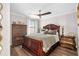 Comfortable bedroom with wood floors, dark wood furniture and a ceiling fan at 12432 Golden Sage Dr, Sarasota, FL 34238