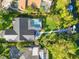 Aerial view of a home with a pool and private dock, showcasing lush landscaping and waterfront access at 1899 Buccaneer Cir, Sarasota, FL 34231