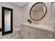 Light and airy bathroom with a single vanity and round mirror at 1899 Buccaneer Cir, Sarasota, FL 34231