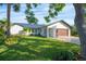 Front view of a charming, updated home with a large grassy yard and modern features at 1899 Buccaneer Cir, Sarasota, FL 34231