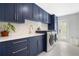 Modern laundry room with navy cabinets and gold accents at 1899 Buccaneer Cir, Sarasota, FL 34231